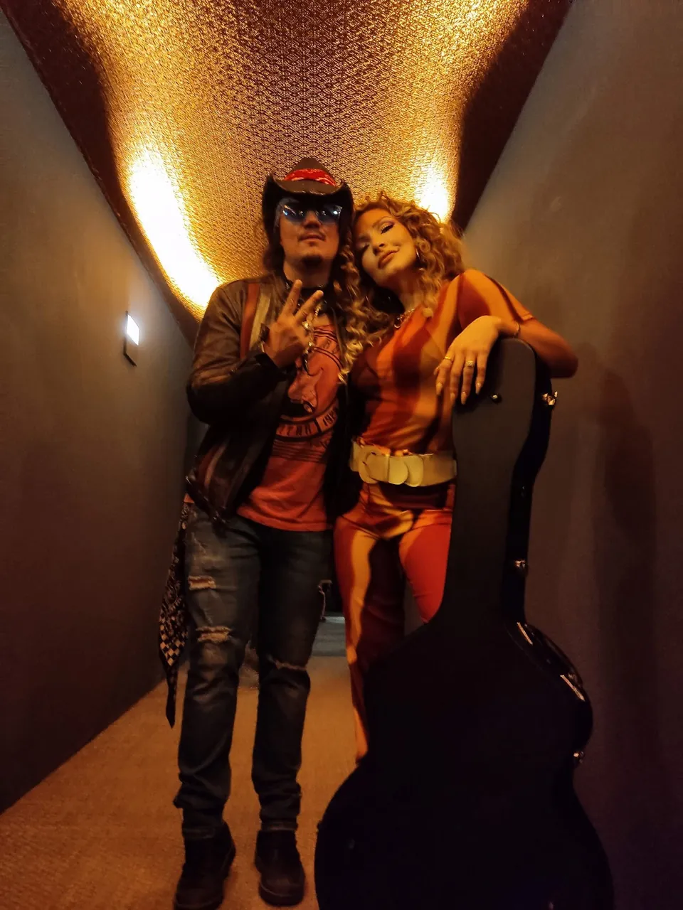 Retrato de Mateo Acevedo en el backstage junto a una acompañante y su estuche de guitarra antes del show.