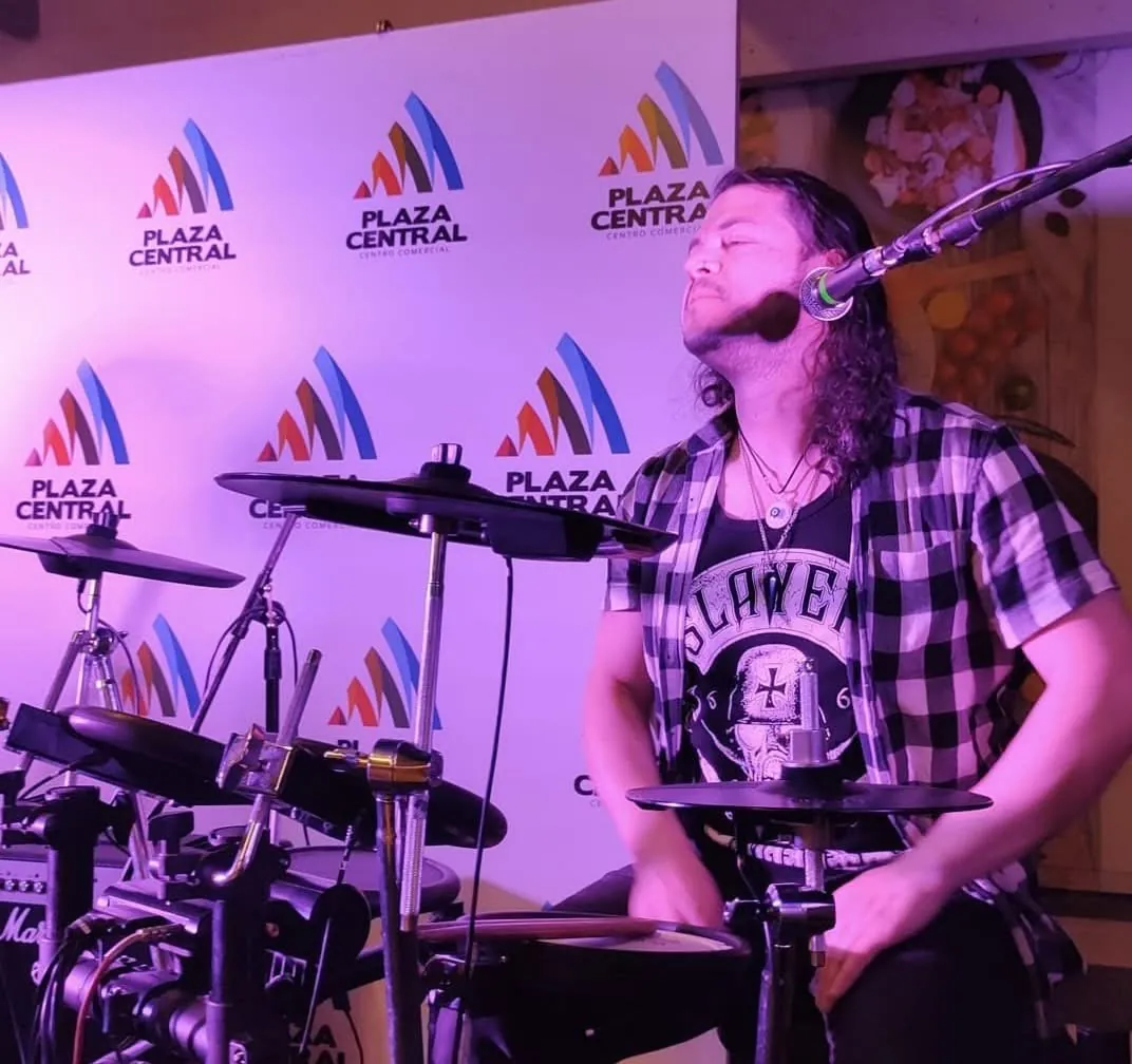 Baterista de la banda de Mateo Acevedo toca la batería electrónica durante una presentación en vivo.
