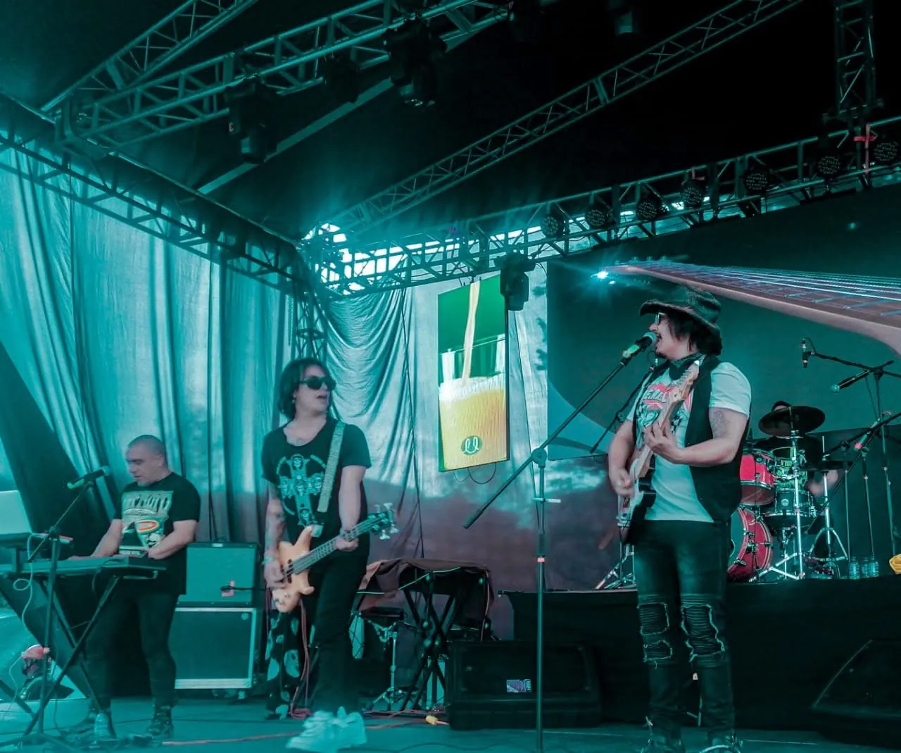 Mateo Acevedo y su banda completa en una presentación en vivo con iluminación verde.