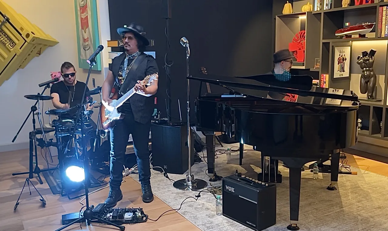 Mateo Acevedo con su banda en un evento privado tocando guitarra, batería y piano.