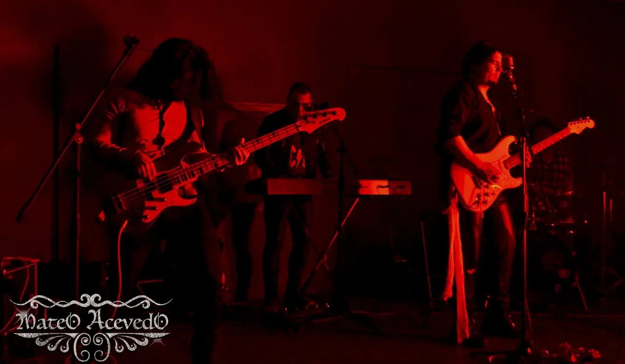 Mateo Acevedo junto a su banda en una presentación en vivo de rock bajo intensa luz roja en el escenario.