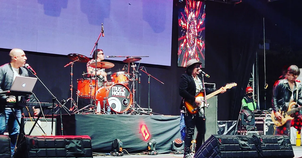 Mateo Acevedo y su banda en vivo en la tarima de un festival con pantallas y luces.