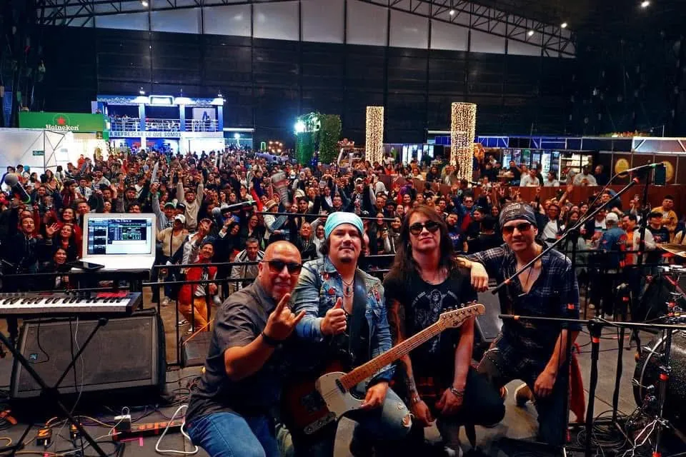 Mateo Acevedo con su banda en la tarima y un público numeroso detrás en un evento masivo.