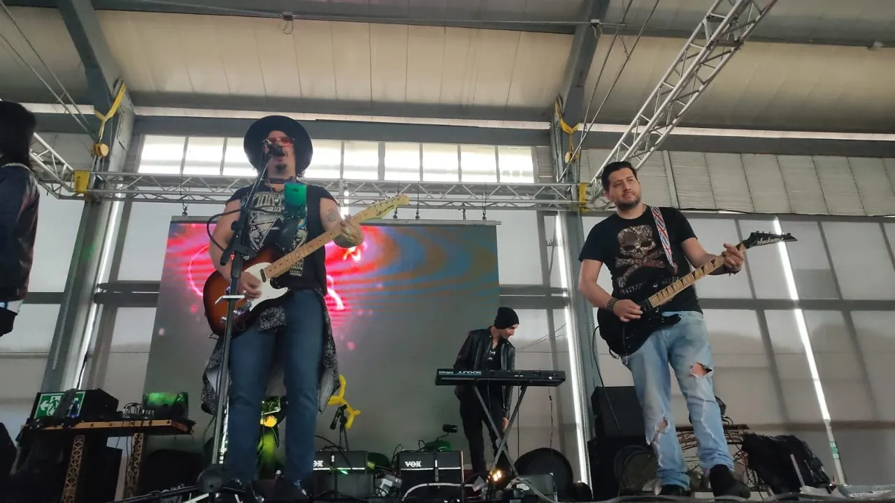 Mateo Acevedo y su banda de rock en vivo en un escenario tipo bodega durante el día.
