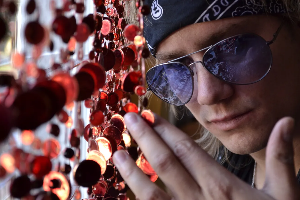Retrato artístico de Mateo Acevedo con gafas entre esferas rojas