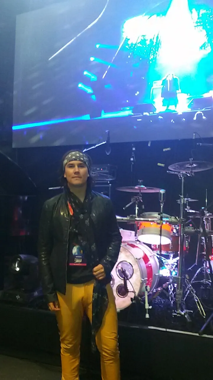 Mateo Acevedo en concierto sobre un escenario con pantalla LED y batería