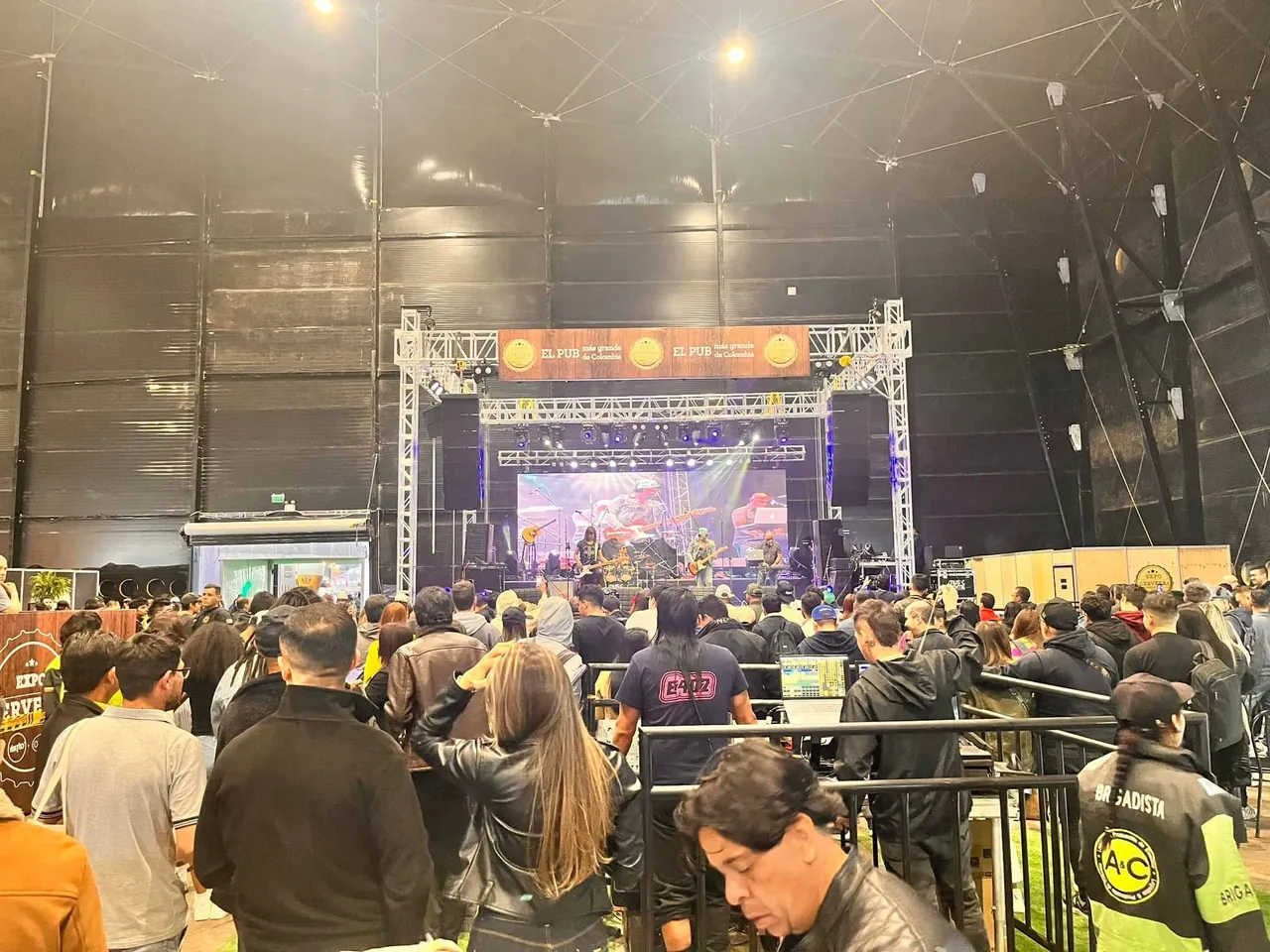 Público de un concierto en vivo frente a la tarima en un gran pabellón de eventos.