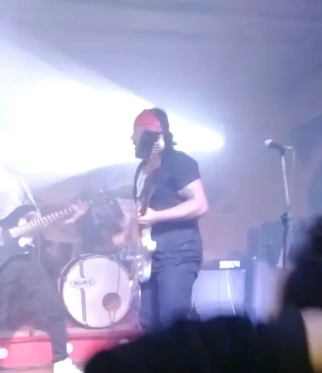 Mateo Acevedo tocando guitarra eléctrica en un concierto de rock en vivo, con luces de escenario y público.