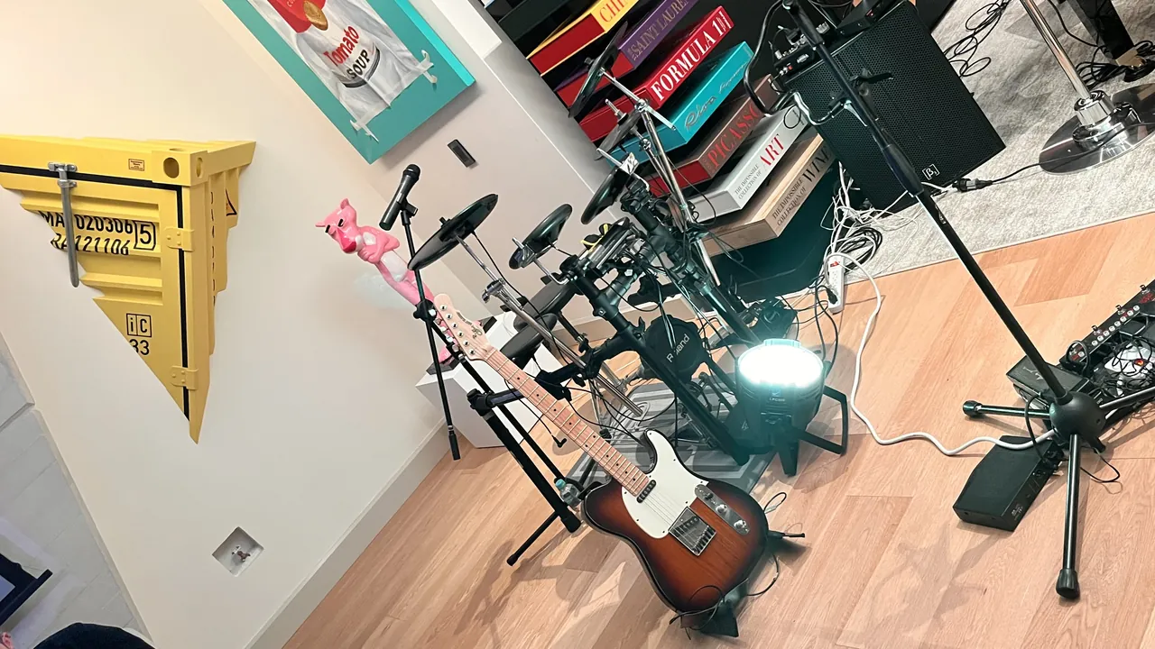 Guitarra eléctrica Telecaster y batería electrónica en un estudio de ensayo de música en vivo.