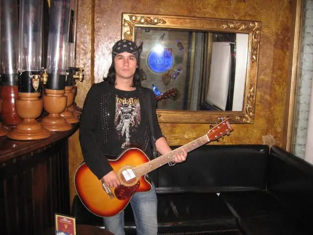 Mateo Acevedo posando con su guitarra acústica en un bar antes de un show en vivo.