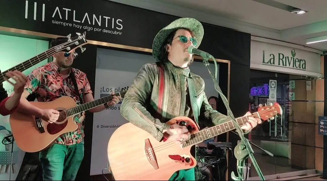 Mateo Acevedo interpreta la guitarra acústica con sombrero durante una presentación en vivo.