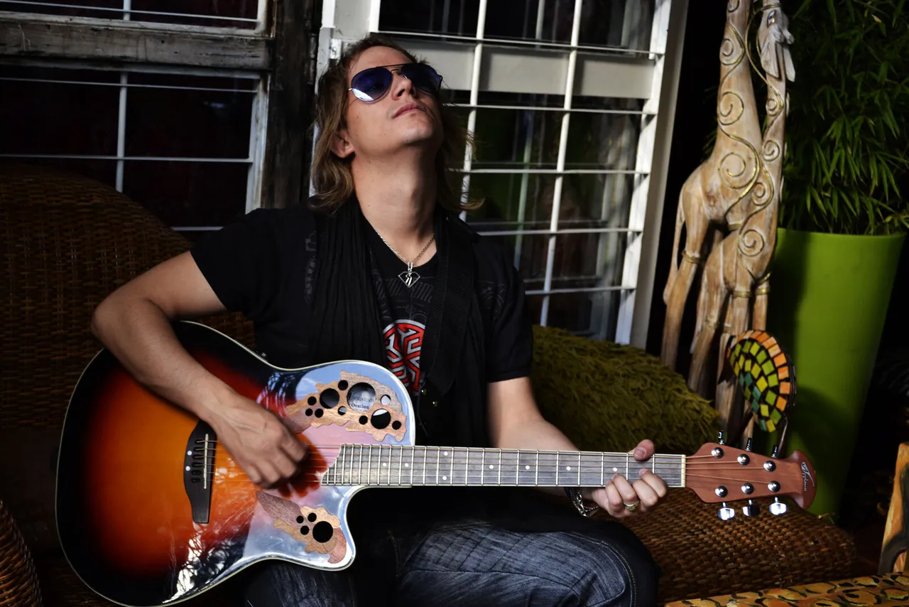 Mateo Acevedo tocando guitarra eléctrica en un ambiente lounge interior