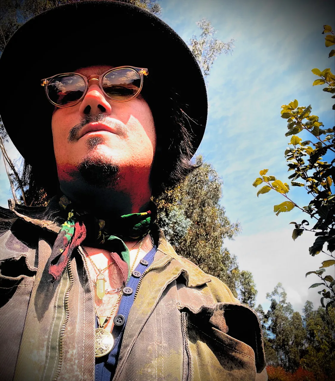 Retrato de Mateo Acevedo con sombrero y gafas bajo el cielo azul