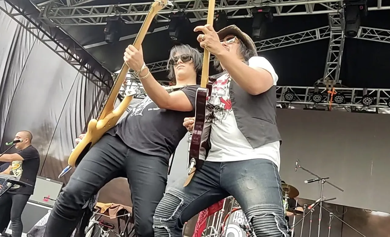 Mateo Acevedo posa con su guitarra junto al bajista sobre la tarima de un festival.