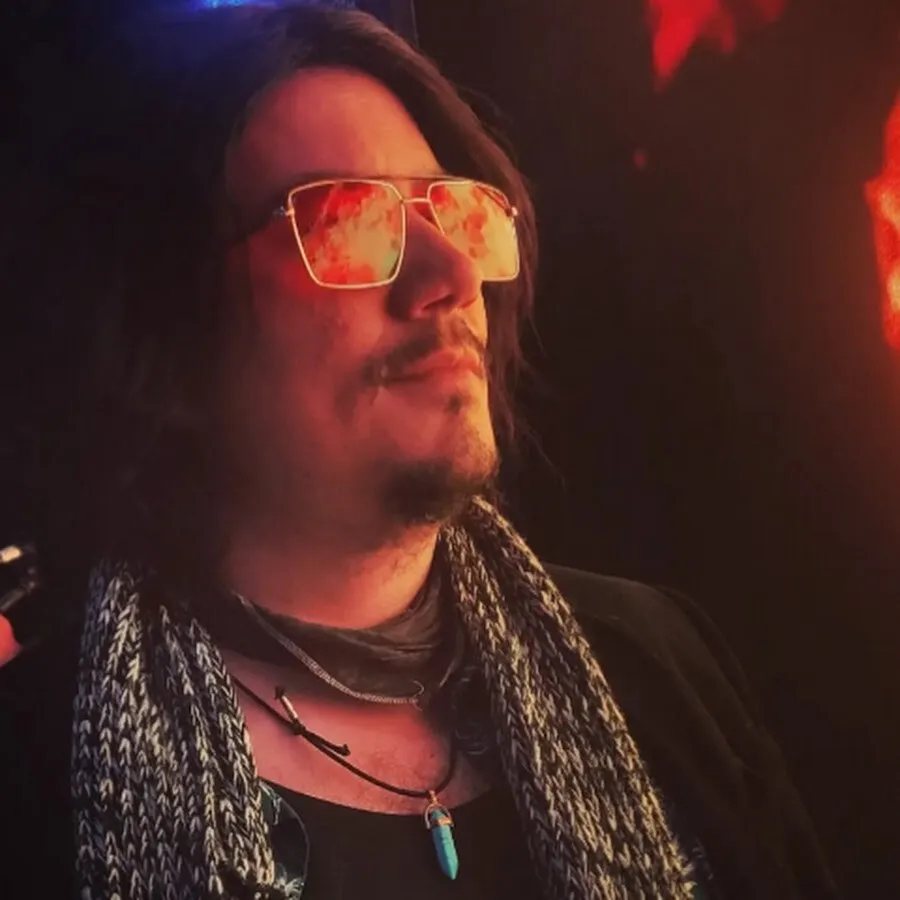 Retrato nocturno de Mateo Acevedo con gafas bajo luz roja
