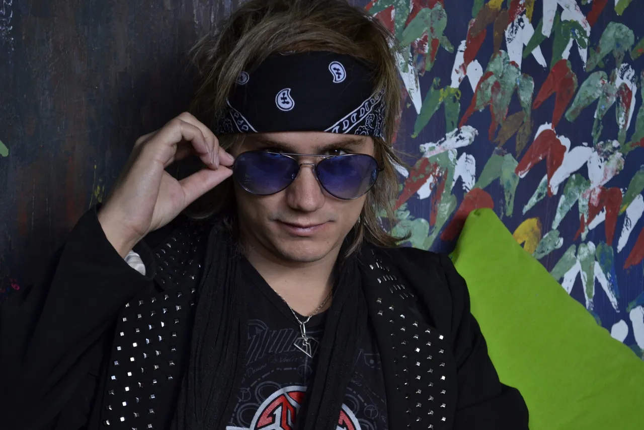 Retrato de Mateo Acevedo con pañoleta y gafas sobre un fondo urbano
