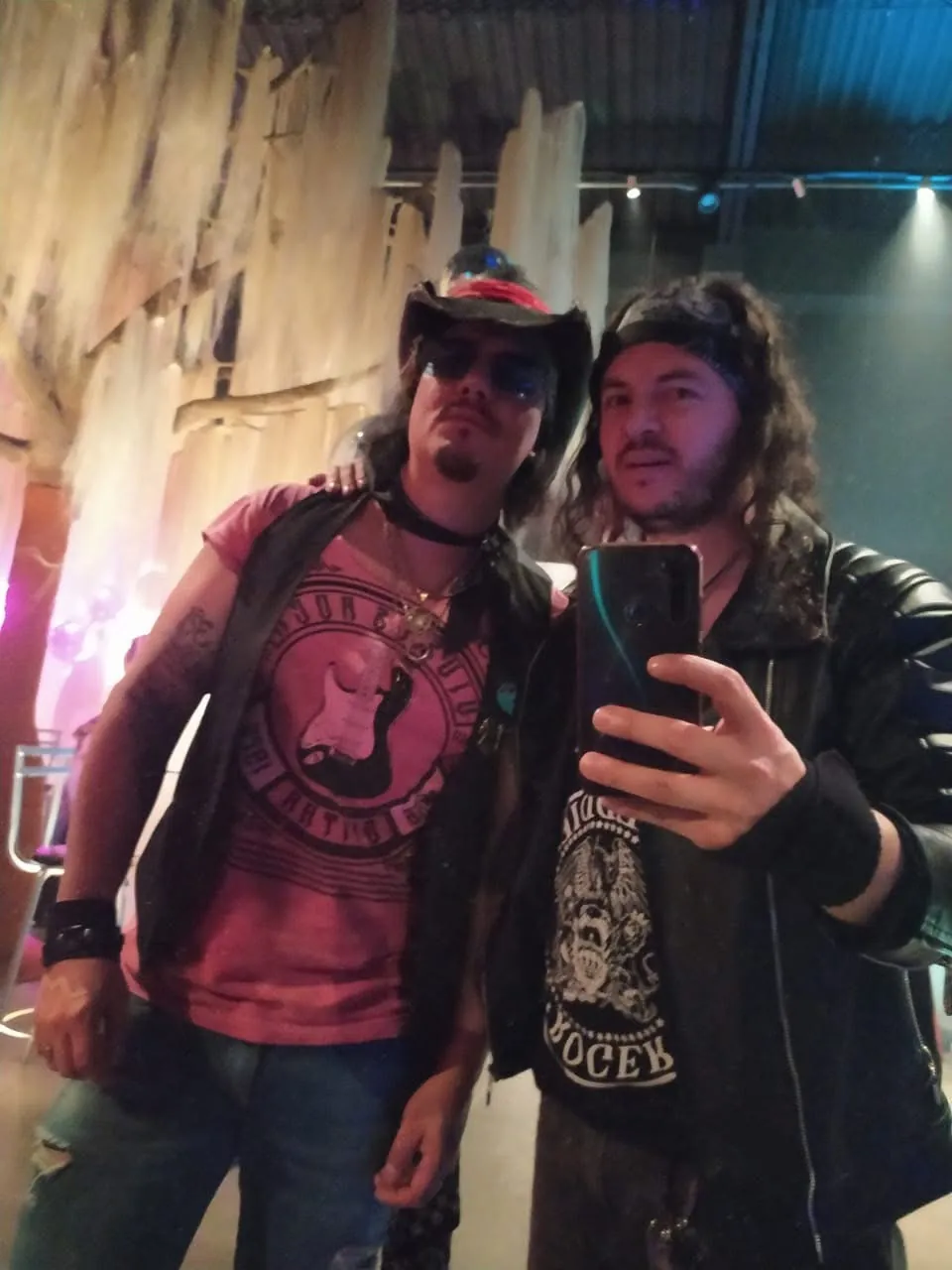 Mateo Acevedo posa para una selfie frente al espejo junto a un compañero en el camerino de un evento.