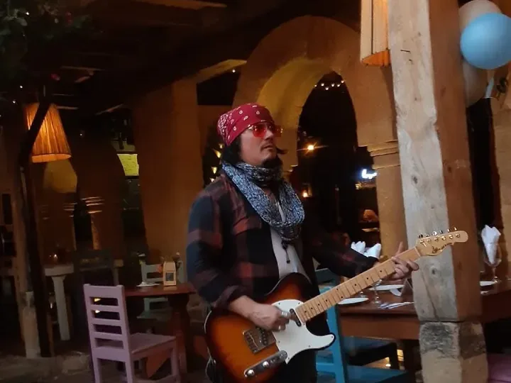Mateo Acevedo recorre con su guitarra el patio de un restaurante en Bogotá, al estilo de una serenata en vivo