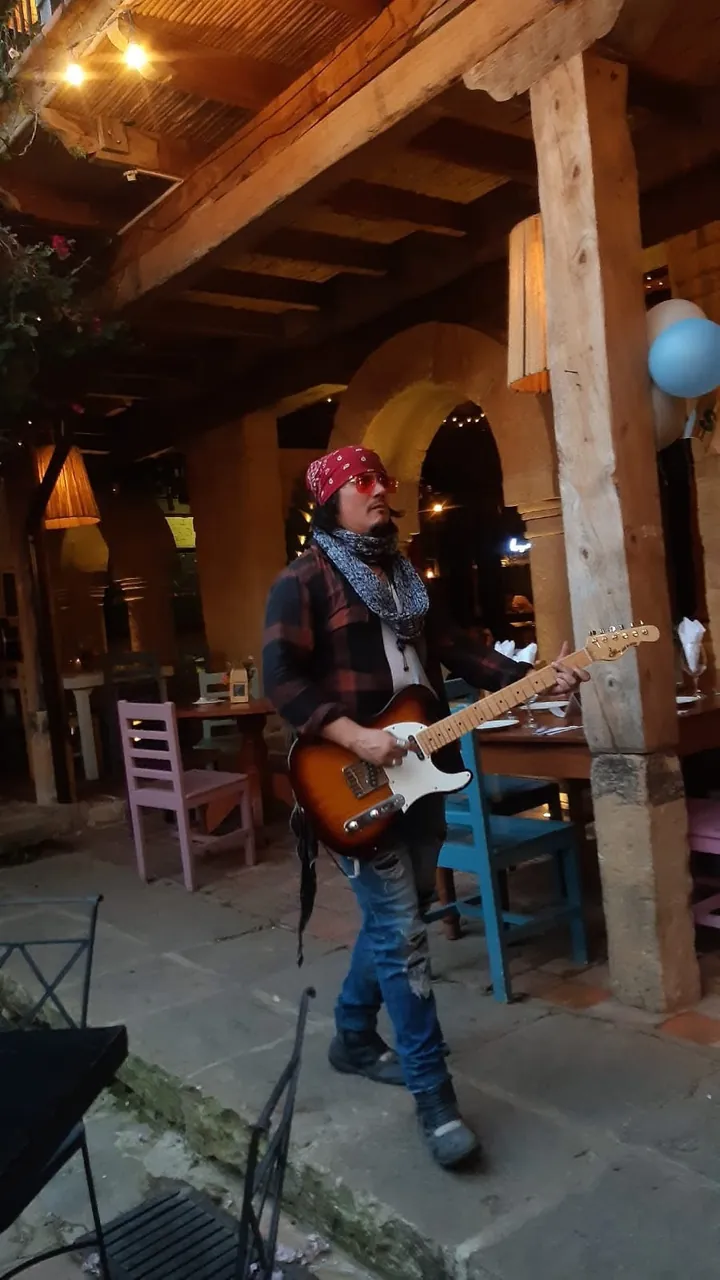 Mateo Acevedo toca la guitarra recorriendo el patio de un restaurante colonial, al estilo serenata.