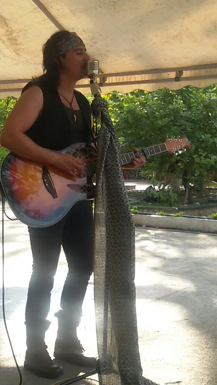 Mateo Acevedo tocando guitarra en vivo en un evento al aire libre