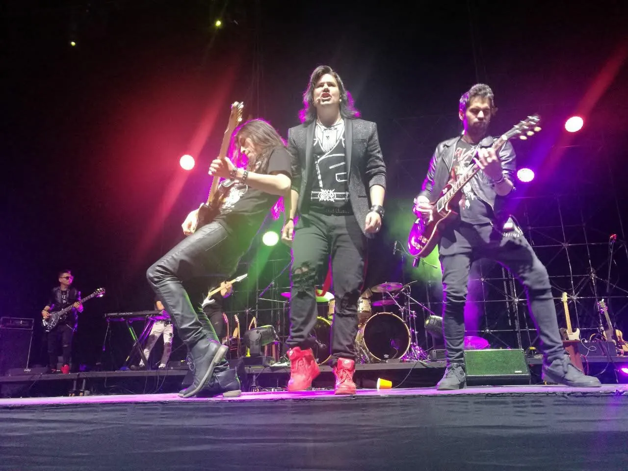 Mateo Acevedo al frente de su banda durante un enérgico show de rock en vivo con luces de colores.