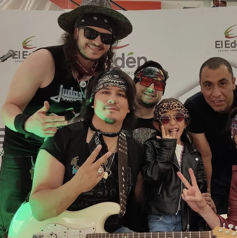 Mateo Acevedo y su banda en un show tributo de rock posan con asistentes en un centro comercial.